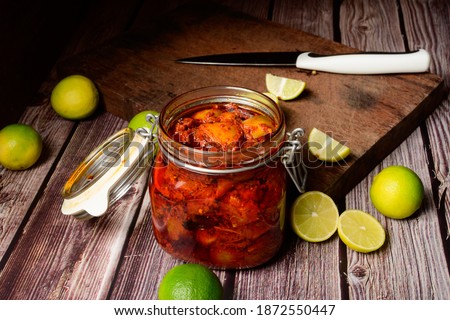 Indian home made spicy lemon pickle in a jar on a wooden background selective focus Royalty-Free Stock Photo #1872550447