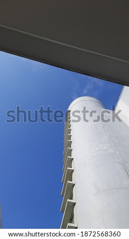 An exterior of a tall building taken from below with a blue clear sky as a background