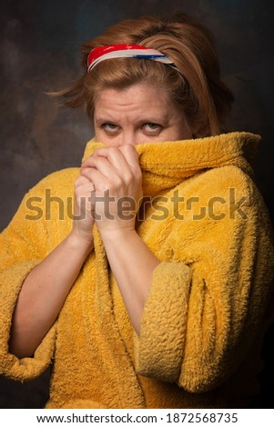 Photo of a man with an emotion on his face. Clothes for household use are yellow. Warm bathrobe salvation from the cold.