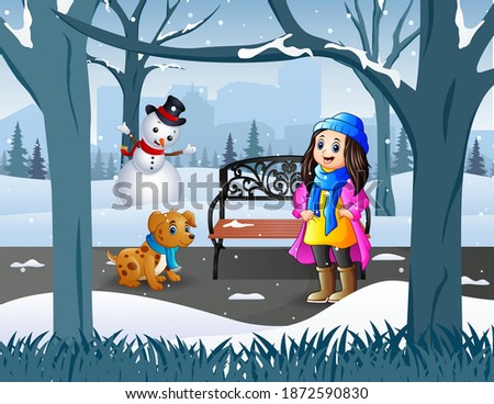 A girl with her pet walking in the snowy park