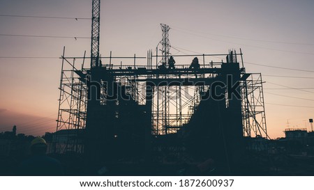Blurred  industry background Silhouette Engineer and construction team working at site  with Light fair Film Grain effect. 