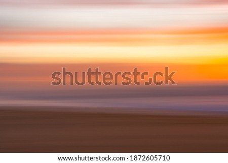 Golden sunset on the beach, an  abstract seascape with blurred panning motion in soft colors