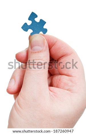 male fingers holding jigsaw puzzle piece isolated on white background
