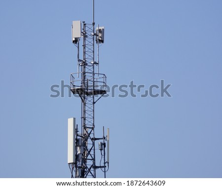 Telecommunication tower of 4G and 5G cellular. Macro Base Station. 5G radio network telecommunication equipment with radio modules and smart antennas mounted on a metal on blue sky background.