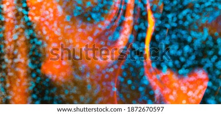 Colorful background with natural bokeh texture and defocused sparkling lights. Teal and orange flames blur with background with twinkling lights. Festive overlay colors with copy space banner