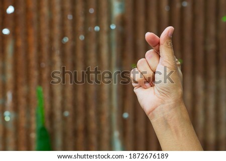 Female hands on the old zinc background. Isolated Finger