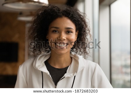 Profile picture of smiling young African American woman talk on video call in office. Headshot portrait of happy millennial biracial female employee show confidence and success. Leadership concept.