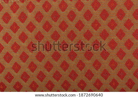 Yellow fabric with red lozenges as the background texture. Close-up long and wide texture of natural red fabric. Fabric texture of natural cotton or linen textile material. Fashion concept design