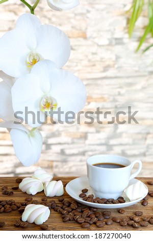 Black coffee and marshmallow on a stone wall background and orchids