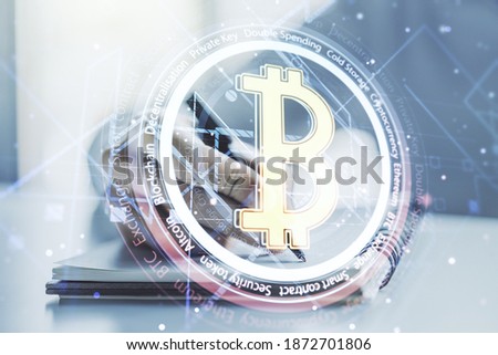 Double exposure of creative Bitcoin symbol with man hand writing in notebook on background. Cryptocurrency concept