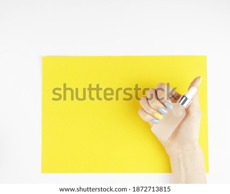 Woman hands holding oil or serum cosmetics on yellow and white background. Skincare concept. Place for your text.