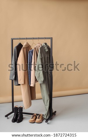 Clothes on a hanger on a beige background. Wardrobe from a stylist.