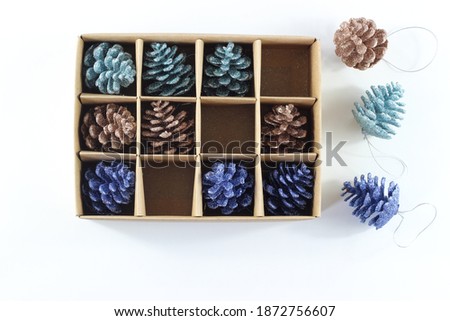 Modern Minimalist Box assortment of Christmas Decoration on white background. Blue and Gold Glitter,  Flat lay, Top view.
