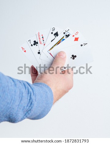 Hand holding cards Joker in the middle