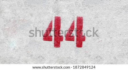 Red Number 44 on the white wall. Spray paint.