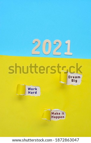 Dream big, work hard and make it happen text written on torn colorful paper with 2021 background. 2021 New year concept