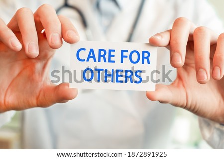 CARE FOR OTHERS card in hands of medical doctor, medical concept