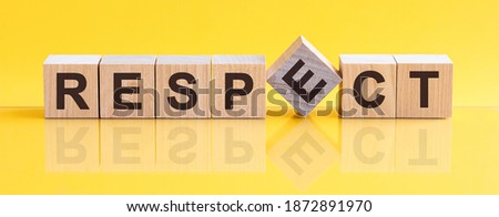 Respect word written on wood block. Respect word is made of wooden building blocks lying on the yellow table. Respect, business concept, yellow background Royalty-Free Stock Photo #1872891970