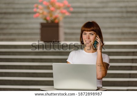 Young female copywriter talking on phone with client about project