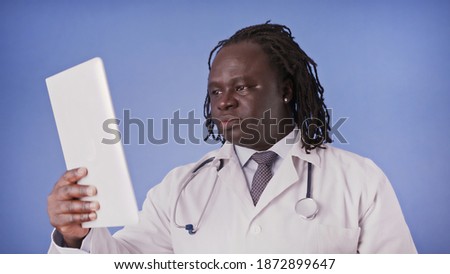 Young african american black man using tablet for medical research. High quality photo