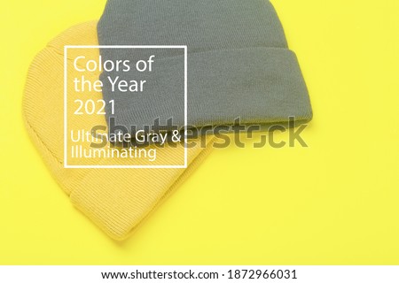 Colors of the year 2021 Ultimate Gray and Illuminating background. Gray and Illuminating 
winter hats on a yellow background. Clothing in design and color trend