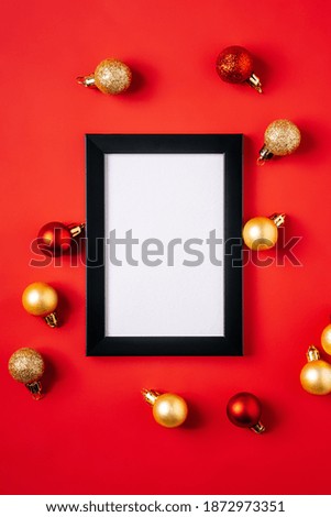 Christmas composition with picture frame mockup. Red and golden ornament and baubles decorations.