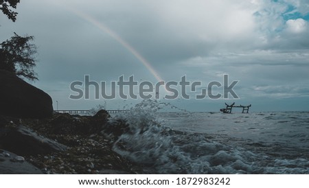 Rainbow view from beach in a stormy day