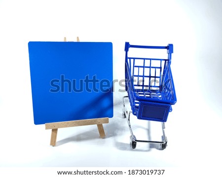 Copy space and text space on blue board and blue trolly isolated on white background.Shopping and education concept.