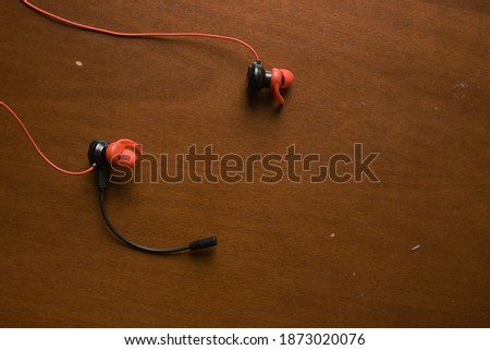 Gaming earphone with microphone stick on wooden background. 
