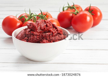 Traditional turkish tomato paste in bowl or spoon with fresh tomatoes on wooden table, homemade healthy food Royalty-Free Stock Photo #1873024876