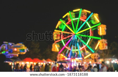 Picture of the unfocused Ferris wheel with multicolored lights.blurred background.with outdoor long exposure at night.