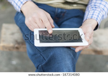 Man with tablet in hand on the street.