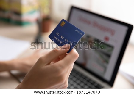 Close up woman holding plastic credit card, using laptop, paying online, young female entering information, browsing banking service, checking balance, shopping in internet, ordering goods Royalty-Free Stock Photo #1873149070