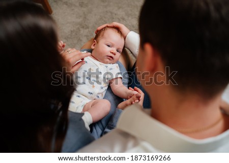 top view. shooting over shoulder. a newborn baby is lying on the lap of his parents. happiness of parenthood. long-awaited pregnancy, extracorporal fertilization. A beautiful family.