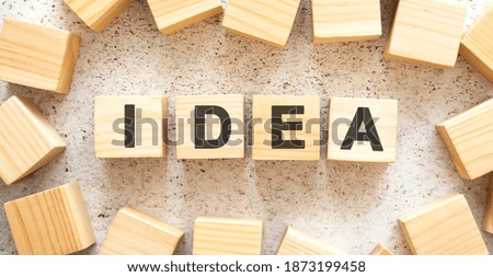 The word IDEA consists of wooden cubes with letters, top view on a light background.