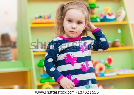 Little girl playing with toys in the playroom