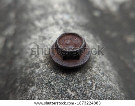 Macro photo of old and dying screws on the roof