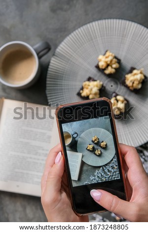 Close up of hands with smartphone taking picture of dessert food. People, leisure, eating and technology concept