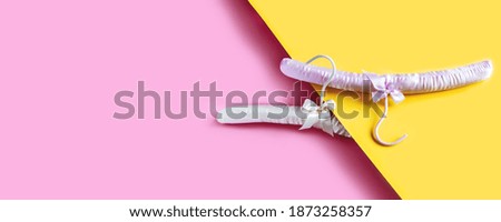 Empty clothes hanger on bright pink and yellow background with copy space. Sale and shopping concept. Banner.