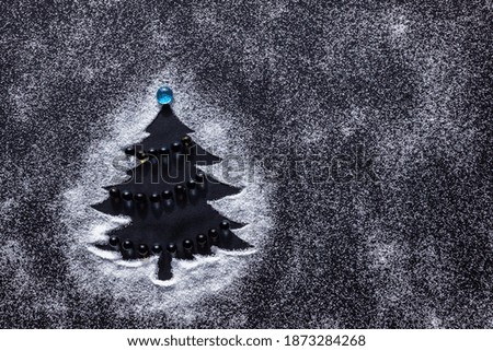 Minimal Christmas tree with sugar snow on dark background. Flat lay. 
