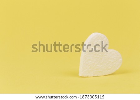 background of white foam hearts on a yellow background close-up