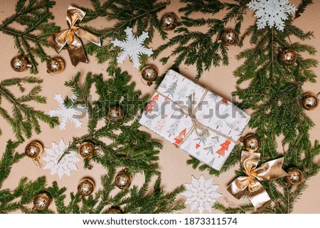 Christmas decorations flat layout with space for text. Fir branches on the cardboard background, snowflakes, gift. Eco-friendly christmas ornaments. Scandinavian christmas cards.