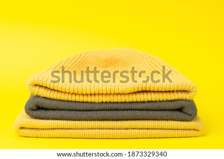Colors of the year 2021 Ultimate Gray and Illuminating background. Gray and Illuminating 
winter hats on a yellow background. Clothing in design and color trend