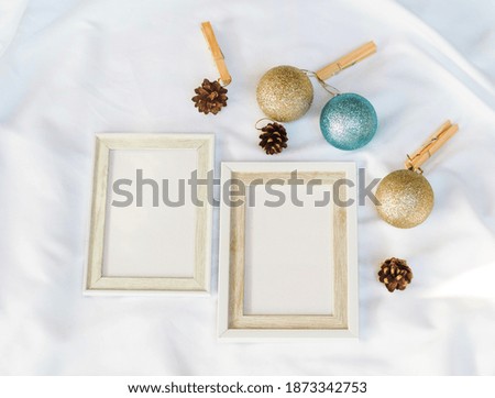 white picture frame with Christmas balls decoration gift on white background, minimal concept. top view, christmas holiday season.