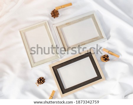 white picture frame with Pine cones decoration on white background, minimal concept. top view, vintage 