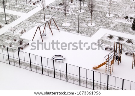 Top view of empty Playground and winter Park paths are covered with snow