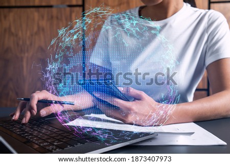 Businesswoman typing on laptop in office. Planet earth world map hologram. International business concept. Double exposure.