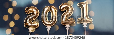 2021 the numbers on the inflated gold balls with bokeh from the lights of the garland. The concept of new year and Christmas. Banner.
