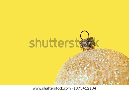 Banner top of shiny Christmas tree ball on bright yellow background with copy space. High quality photo