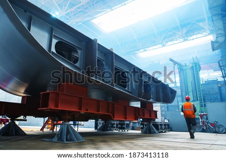 The construction of a large ship. A fragment of the case in the workshop of the plant. Keel trawler at stops during assembly. Selective focus Royalty-Free Stock Photo #1873413118